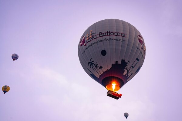 Captivating view of hot air balloons soaring over Göreme during sunrise, offering a serene adventure.